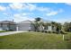 Lovely home with a two-car garage, manicured lawn, and beautiful landscaping at 194 Sunset Rd, Rotonda West, FL 33947