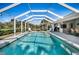 A screened pool boasts inviting turquoise water and ample lounge space with tropical landscaping at 194 Sunset Rd, Rotonda West, FL 33947