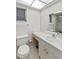 Well-lit bathroom featuring a glass-enclosed shower, toilet, sink, and a large mirror at 3220 Southfield Ln # 810, Sarasota, FL 34239