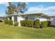 Inviting one-story home showcasing large windows, lush green bushes, and a well-manicured lawn at 3220 Southfield Ln # 810, Sarasota, FL 34239