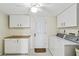 Bright laundry room with white cabinetry and appliances, with tile flooring and lots of storage at 3220 Southfield Ln # 810, Sarasota, FL 34239