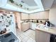 Functional kitchen featuring light cabinets, white appliances, a large window, and tiled floor at 501 Cobalt Rd, Englewood, FL 34223