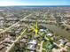 An aerial view of a residential area pointing to a home featuring a pool and backyard with lake views in the distance at 7424 Snow Dr, Englewood, FL 34224