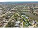 Expansive aerial view of a residential community featuring a tranquil pond and neatly arranged single-Gathering homes at 7424 Snow Dr, Englewood, FL 34224