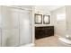 Bathroom featuring a glass enclosed shower and double sink vanity with dark wood cabinets at 7424 Snow Dr, Englewood, FL 34224