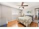 Comfortable bedroom features a ceiling fan, wood floors and shuttered windows at 7424 Snow Dr, Englewood, FL 34224