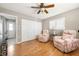 Bedroom with ceiling fan, hardwood floors, closet, chairs, and neutral decor at 7424 Snow Dr, Englewood, FL 34224