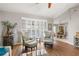 Bright living room with wood floors, stylish seating, and view of the pool through plantation shutters at 7424 Snow Dr, Englewood, FL 34224