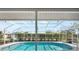 Screened-in pool in backyard features tiled edge and plenty of space for lounging at 7424 Snow Dr, Englewood, FL 34224