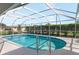 Inviting screened-in pool with a sun deck and lush landscaping in the backyard at 7424 Snow Dr, Englewood, FL 34224