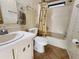 Bathroom featuring a shower-tub combo, palm-themed shower curtain, and a tiled floor at 810 Manchester Ct, Englewood, FL 34223