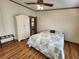 Bedroom with wood floors, ceiling fan, and a bed at 810 Manchester Ct, Englewood, FL 34223