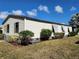 Home exterior with white siding, brown trim, and manicured landscaping on a sunny day at 810 Manchester Ct, Englewood, FL 34223