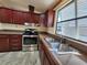 This is the kitchen area, featuring dark wood cabinets and stainless steel appliances at 810 Manchester Ct, Englewood, FL 34223