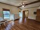 Comfortable main bedroom featuring wood floors, a ceiling fan, and views of the private back yard at 810 Manchester Ct, Englewood, FL 34223