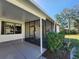 Home's enclosed patio featuring concrete floors, windows, landscaping, and access to backyard at 810 Manchester Ct, Englewood, FL 34223