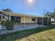 View of the home's patio, showing the screened enclosure, concrete flooring, and partial backyard view at 810 Manchester Ct, Englewood, FL 34223