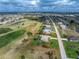 Aerial view of a home with a backyard pool and golf course, surrounded by lush landscaping at 934 Rotonda Cir, Rotonda West, FL 33947