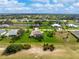 Aerial view of a home with a screened-in lanai, set in a neighborhood with lush vegetation at 934 Rotonda Cir, Rotonda West, FL 33947