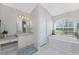 Bright bathroom with a soaking tub under an arched window, vanity, and tiled floors at 934 Rotonda Cir, Rotonda West, FL 33947