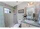 Cozy bathroom with shower, toilet, vanity, and decorative mirror at 934 Rotonda Cir, Rotonda West, FL 33947