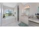 Bathroom featuring a soaking tub beneath an arched window, vanity, and shower at 934 Rotonda Cir, Rotonda West, FL 33947