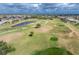 Scenic aerial view of a golf course featuring putting greens, sand traps, and ponds at 934 Rotonda Cir, Rotonda West, FL 33947