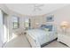 Sunlit main bedroom with large windows, a patterned bedspread, and bedside table at 934 Rotonda Cir, Rotonda West, FL 33947