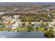 Aerial view of house on lake with surrounding homes and landscape at 12321 Smokey Dr, Hudson, FL 34669