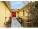 Inviting entryway with red door and landscaped walkway at 12321 Smokey Dr, Hudson, FL 34669