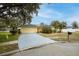 Bright yellow house with a red door and a large driveway at 12321 Smokey Dr, Hudson, FL 34669