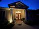 Elegant home exterior at night with lit columns and entryway at 1108 Bayhead Ln, Osprey, FL 34229