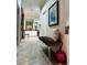 Long hallway with decorative bench and artwork leading to bedroom and bathroom at 1108 Bayhead Ln, Osprey, FL 34229