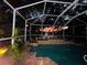 Night view of a relaxing pool area with a screened enclosure and lake view at 1108 Bayhead Ln, Osprey, FL 34229