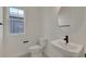 A half bathroom features a modern sink, toilet, and a window providing natural light at 9039 Duany Ln, Lakewood Ranch, FL 34240