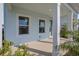 Inviting front porch with white columns and a view of lush landscaping at 9039 Duany Ln, Lakewood Ranch, FL 34240