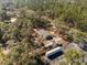 Aerial view of this home, surrounded by lush trees, with an extended driveway and parking at 2044 Culbreath Rd, Brooksville, FL 34601