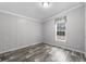 The light and airy bedroom has wood-look flooring and a large window at 2044 Culbreath Rd, Brooksville, FL 34601