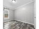 A simple, neutral bedroom has wood-look floors and a window for natural light at 2044 Culbreath Rd, Brooksville, FL 34601