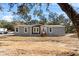 Beautiful single Gathering home with gray siding, brown trim, and green trees at 2044 Culbreath Rd, Brooksville, FL 34601