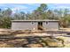 The house features gray siding, a small deck and well-maintained lawn at 2044 Culbreath Rd, Brooksville, FL 34601