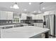 Bright kitchen featuring white cabinets, stainless steel appliances, grey subway tile backsplash, and a large marble-look island at 2044 Culbreath Rd, Brooksville, FL 34601