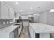 Open kitchen view featuring stainless steel appliances, island, modern backsplash, and stylish white cabinets at 2044 Culbreath Rd, Brooksville, FL 34601