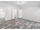 Large empty room with grey wood floors; perfect for customization at 10215 Poplar St, New Port Richey, FL 34654