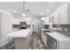 Well-lit kitchen featuring stainless steel appliances, a farmhouse sink, and a marble countertop island at 10215 Poplar St, New Port Richey, FL 34654