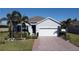 Single-story home with gray exterior, white garage door, and palm trees at 24692 Rio Villa Lakes Cir, Punta Gorda, FL 33950