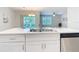 Kitchen island with double sink and white cabinets at 24692 Rio Villa Lakes Cir, Punta Gorda, FL 33950