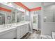 Modern bathroom with double vanity, white cabinets, and gray tile floors at 813 Old Windsor Way, Spring Hill, FL 34609