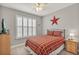 Bedroom with red plaid bedding and large window at 813 Old Windsor Way, Spring Hill, FL 34609