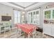 Bright dining area with a red and white checkered tablecloth and built-in shelving at 813 Old Windsor Way, Spring Hill, FL 34609